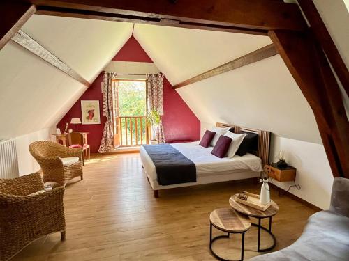 a bedroom with a bed in a room with a roof at Domaine de Joreau in Gennes