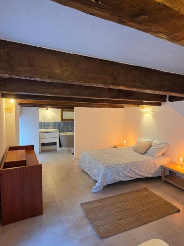 a bedroom with a large bed and a bathroom at Lavande in Beaumont-de-Pertuis