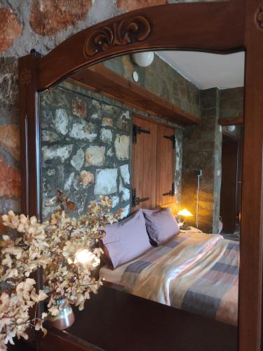 a bedroom with a bed in a stone wall at Studio in Elatochori - O Elato in Elatochori
