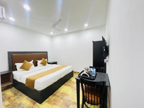 sypialnia z łóżkiem i biurkiem z telewizorem w obiekcie Hotel Vasundhara Villa - Greater Kailash w Nowym Delhi