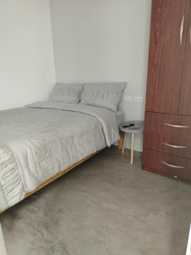 a bedroom with a bed and a wooden cabinet at Casa Reyna in Hacienda Cienguilla