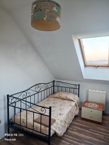 a bedroom with a black bed and a window at Oko na Mogielice in Słopnice