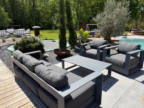 a patio with couches and a table and a pool at Villa golf merignies in Mérignies