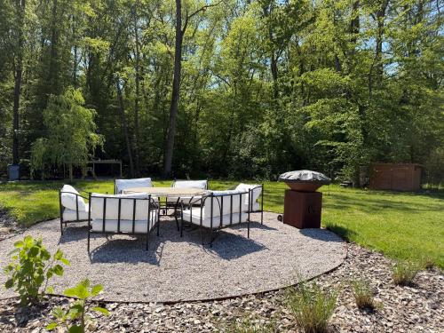 a patio with a table and chairs and a grill at Villa golf merignies in Mérignies