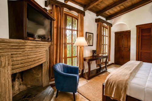 a bedroom with a bed and a tv above a fireplace at Nifu nifa in Antigua Guatemala