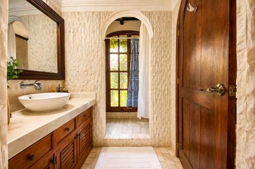 a bathroom with a sink and a mirror and a door at Nifu nifa in Antigua Guatemala