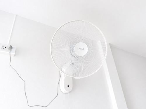 In einem Zimmer hängt ein weißer Ventilator an der Wand. in der Unterkunft Seamsak hotel in Golden Triangle