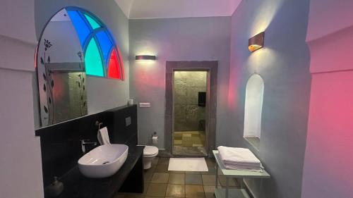 a bathroom with a sink and a toilet and a window at Mandawa Kothi in Mandāwa