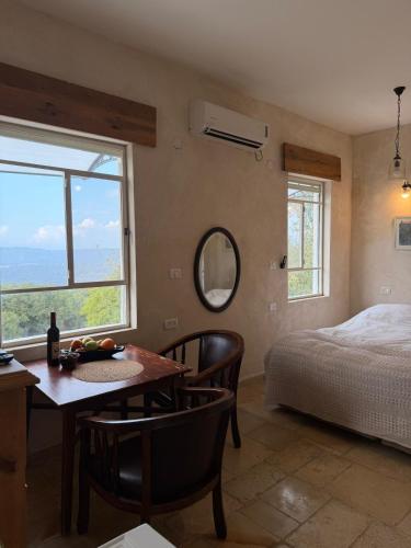 a bedroom with a table and a bed and a window at Benichuta in Mitzpe Hila