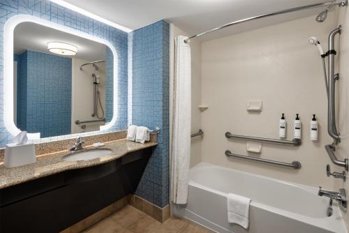 a bathroom with a tub and a sink at Homewood Suites New Brighton in Roseville