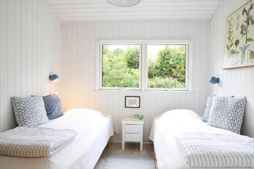 two beds in a white room with a window at 13373-Asnaes-Radyrvej-24 in Asnæs
