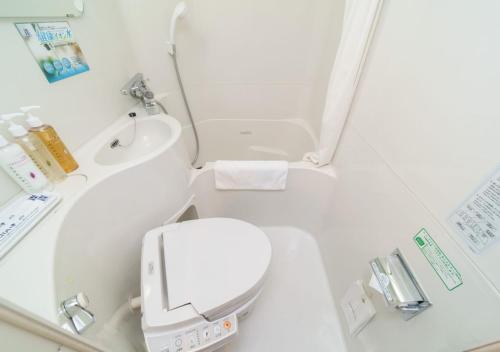 a small bathroom with a toilet and a sink at Super Hotel Midosujisen Esaka in Suita