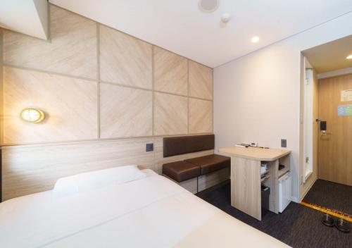 a hotel room with a bed and a desk at Super Hotel Midosujisen Esaka in Suita