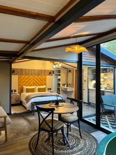 a bedroom with a bed and a table and chairs at Nest-Dove's Nest in Howick