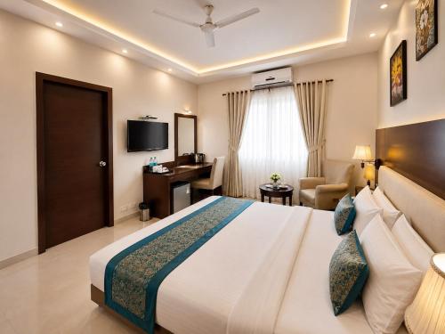 a hotel room with a large bed and a desk at Hotel Sai Jashan Shirdi - Where blessings & comfort meet in Shirdi