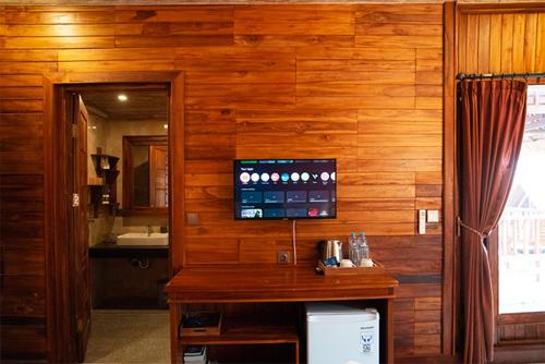 a bathroom with a wooden wall with a sink and a mirror at Pemedal Beach Resort in Nusa Lembongan