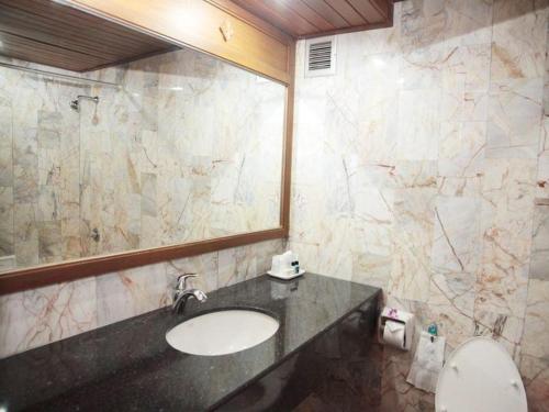 a bathroom with a sink and a mirror at Royal Twins Palace Hotel in Pattaya