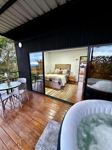 a bedroom with a bed and a table and a tub at Tres Raices Cabañas in Gómez Plata