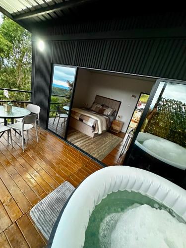 a room with a tub and a bed and a table at Tres Raices Cabañas in Gómez Plata