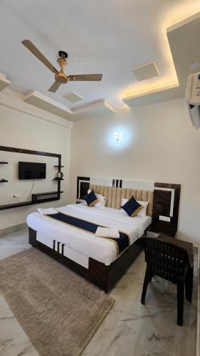 a bedroom with a large bed and a ceiling fan at The Grand Girivar Vrindavan # Lavis & Luxury Rooms # in Vrindāvan