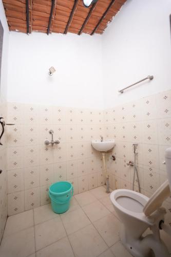 a bathroom with a toilet and a sink at Secret Ashram Coorg in Kushālnagar