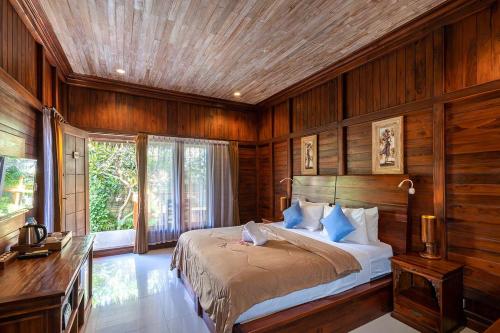 a bedroom with a bed in a room with wooden walls at Pemedal Beach Resort in Nusa Lembongan