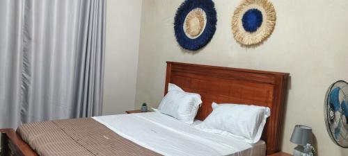 a bedroom with a bed and two wreaths on the wall at Ashland Gardens in Vumba