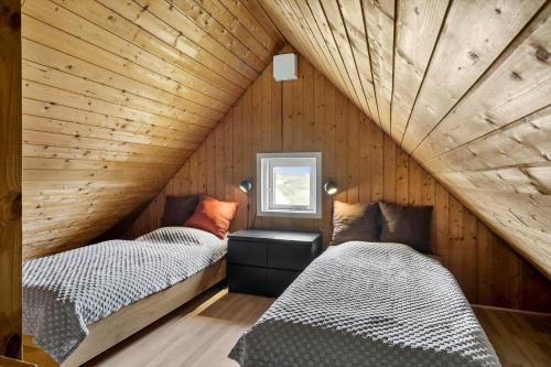two beds in a room with wooden walls at 530-Lemvig-Lokkevej-59-D in Lemvig