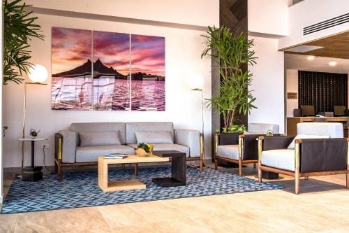 a lobby with couches and a painting on the wall at Comfort Inn Hermosillo Aeropuerto in Hermosillo