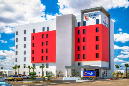 a white and red building with a car dealership at Comfort Inn Hermosillo Aeropuerto in Hermosillo