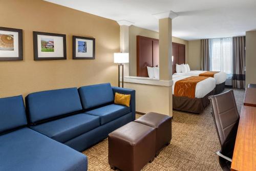 a hotel room with a couch and a bed at Comfort Suites Midland West in Midland
