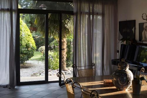 a living room with a table and a sliding glass door at Le Rondini in Grions del Torre