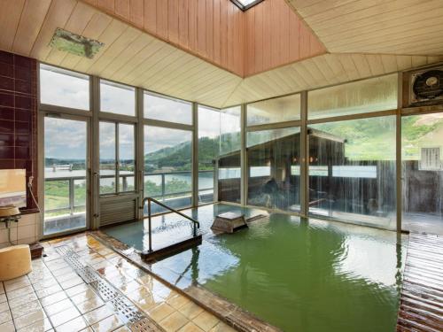 a large pool of water in a room with windows at Bousenkaku in Gosen