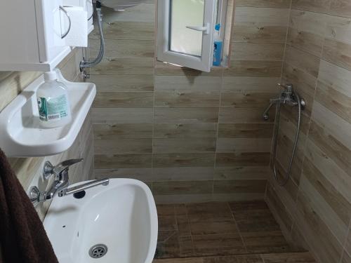a bathroom with a white sink and a shower at Sumski raj Gornje podunavlje in Sombor