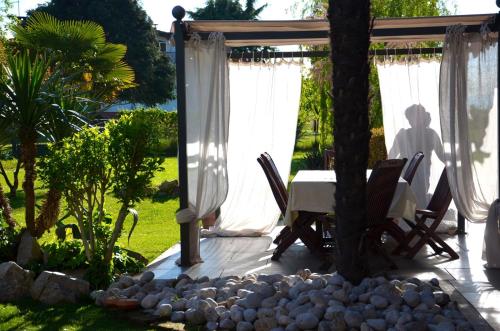 a table and chairs under a pergola in a garden at Le Rondini in Grions del Torre