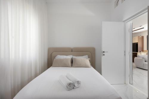 a bedroom with a white bed with towels on it at Katalina Luxury Apartment Eilat in Eilat