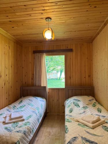 a bedroom with two beds in a log cabin at Kaghu in Martvili