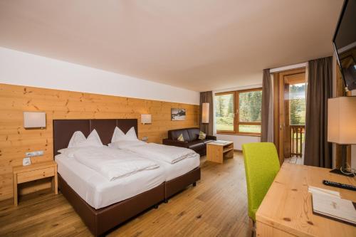 a hotel room with a bed and a desk at Sporthotel Floralpina in Alpe di Siusi