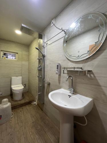 a bathroom with a sink and a mirror and a toilet at Adhunik palace in Keonjhargarh