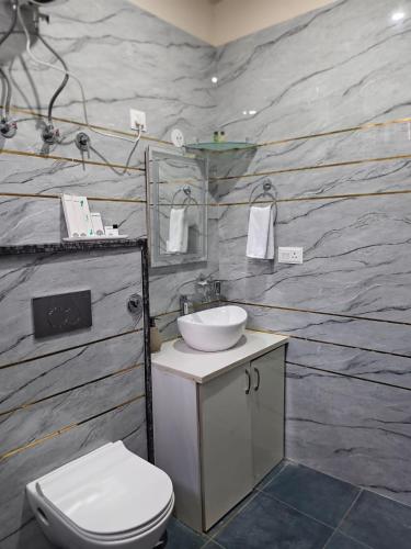 a bathroom with a white toilet and a sink at Hotel Sharma Jaipur in Jaipur