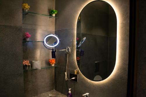 a bathroom with a mirror and a sink at Pillowtalks Cloudnine Stays in Ghaziabad