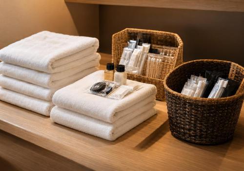 a pile of towels on a table with baskets of towels at Hotel Airport Komatsu in Komatsu