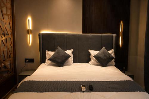 a bedroom with a large bed with white sheets and pillows at Pillowtalks Cloudnine Stays in Ghaziabad