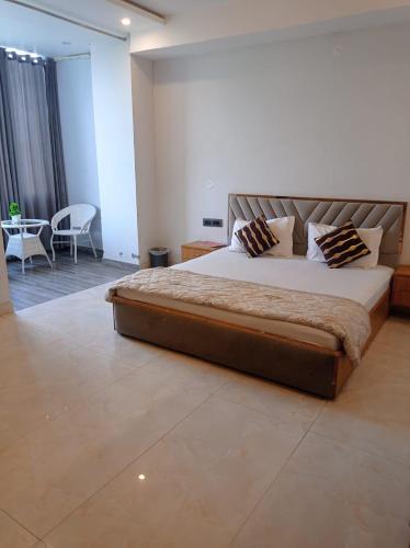 a bedroom with a large bed and a table at Hotel nsb square in Dehradun