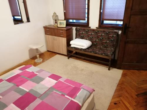 a bedroom with a bed and a chair and windows at Shumata Guest House in Natsovtsi