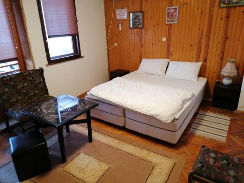 a small bedroom with a bed and a table at Shumata Guest House in Natsovtsi