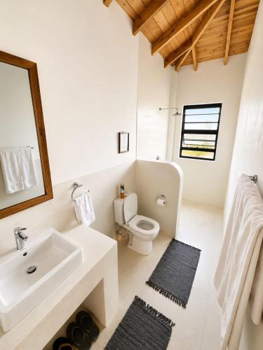 a white bathroom with a sink and a toilet at The Landing Cottages Family Suite 2 Bedroom in Nanyuki