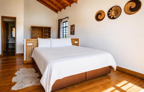 a bedroom with a large bed with white sheets at The Landing Cottages Family Suite 2 Bedroom in Nanyuki