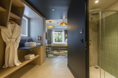 a bathroom with a shower and a sink and a tub at MERCURE NIMES CENTRE ARENES in Nîmes