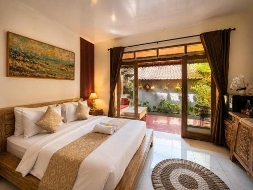 a bedroom with a large bed and a large window at Purnama House Ubud in Ubud